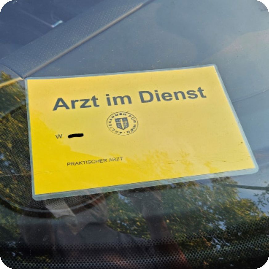 Ein Schild "Arzt im Dienst" liegt im Auto hinter der Windschutzscheibe